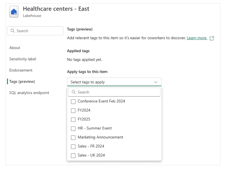 Screenshot of a lakehouse’s Tags settings showing no tags applied yet and the ‘Select tags to apply’ dropdown open with administrator-defined tags such as FY2024, FY2025 and Sales - UK 2024.